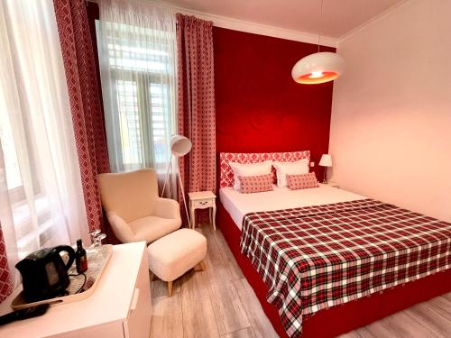 a red bedroom with a bed and a chair at REGINA Bed&Wine in Varna City