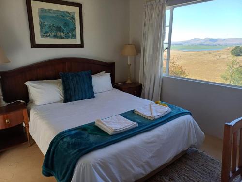 a bedroom with a bed with a large window at Lake View Cottage Unit 7 in Rosetta