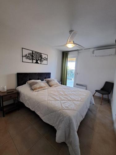 une chambre avec un grand lit et une chaise dans l'établissement T3 proche plage, dans résidence avec piscine, à Calvi
