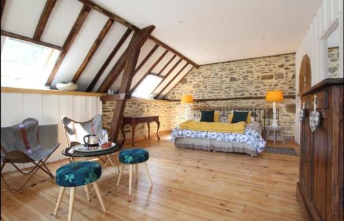a bedroom with a bed and a table and chairs at Maison Priats in Lasseube