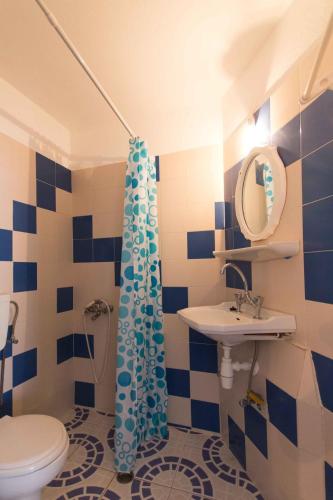 a blue and white bathroom with a toilet and a sink at PAROS APARTMENT MELAS b4 in Parikia