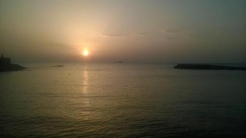 a sunset over the water with the sun in the sky at PAROS APARTMENT MELAS b4 in Parikia