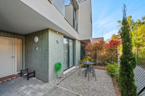 a patio with a table and chairs in front of a building at Newly Built 4 Bedrooms Property in Vésenaz