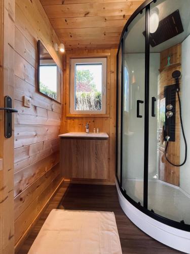 une salle de bain avec une baignoire, un lavabo et une fenêtre dans l'établissement Bungal'eau, à Sciez