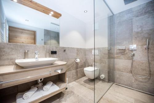 a bathroom with a sink and a glass shower at Pepi's Suites - Lechtal Apartments in Holzgau
