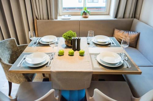 a dining room table with plates and glasses on it at Pepi's Suites - Lechtal Apartments in Holzgau