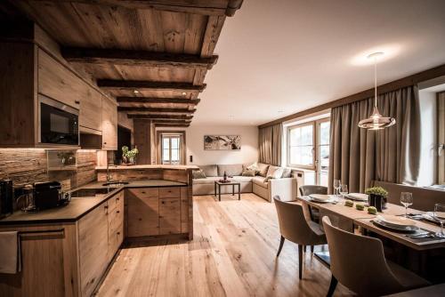 a kitchen and living room with a table and chairs at Pepi's Suites - Lechtal Apartments in Holzgau