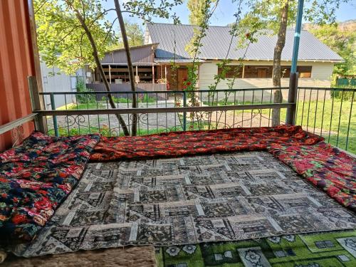 a bed with a quilt on top of a fence at Guest House Turna in Arkit