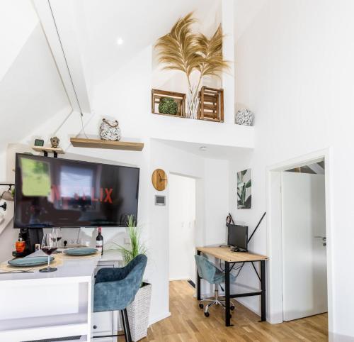 a living room with a desk and a tv at Premium Suite - Waldblick - Balkon - Schwarzwald in Bühl
