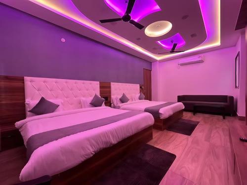 a purple bedroom with two beds and a purple ceiling at The Vrindavan Inn in Vrindāvan