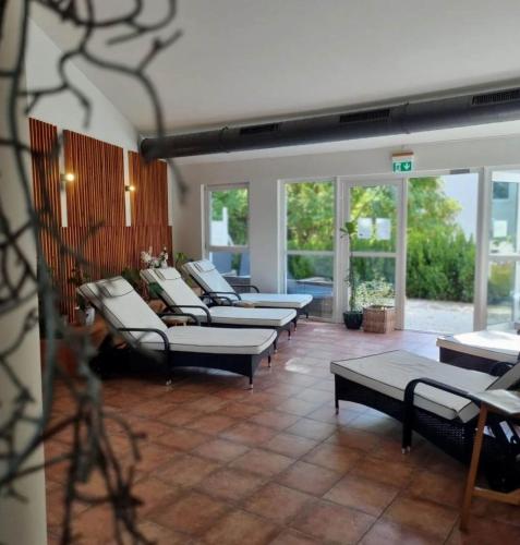 a room with several couches and tables and windows at Fewo-Suite Seeblick mit Terrasse in Ascheberg