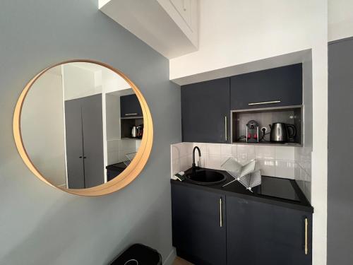 - une cuisine avec un évier et un miroir dans l'établissement Superbe appartement moderne idéalement situé, Lyon, à Lyon
