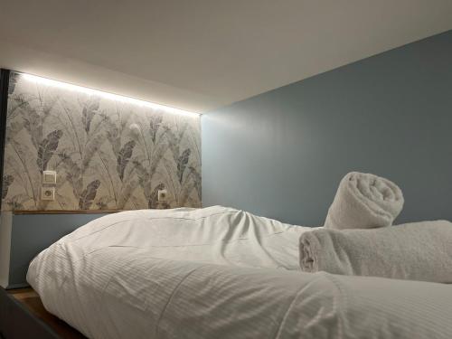 une chambre avec un lit blanc avec un tableau sur le mur dans l'établissement Superbe appartement moderne idéalement situé, Lyon, à Lyon