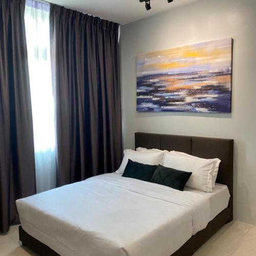 a bed in a bedroom with a painting on the wall at LeStarry Homestay in Kuching