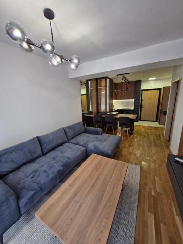 a living room with a blue couch and a table at Royal Apartments in Skopje