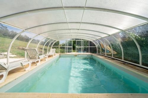 an indoor swimming pool with a retractable roof and a swimming poolvisor at Quinta da Barrosa in Tentúgal
