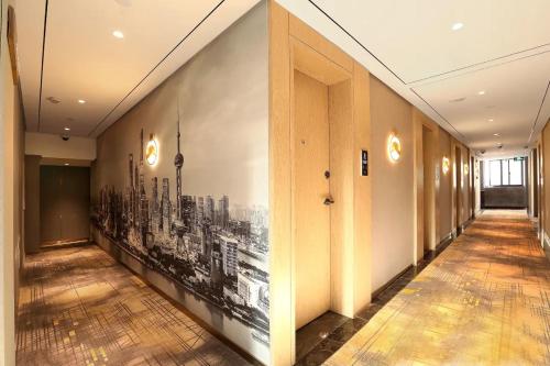 a hallway with a black and white painting on the wall at Weiting Hotel Shanghai Jing'an Temple Nanjing West Road Subway Station Branch in Shanghai