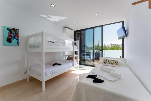 una camera con un letto a castello bianco e un divano di Mira Luz - Luz de Tavira a Luz de Tavira