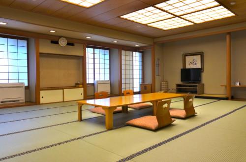 a conference room with a table and chairs and a screen at Kinugawa Onsen Hotel in Nikko