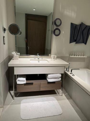 a bathroom with a sink and a tub and a mirror at Marassi luxury suites , the Address Resort , North coast in El Alamein