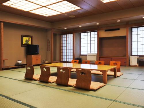 a conference room with a table and chairs and a screen at Kinugawa Onsen Hotel in Nikko