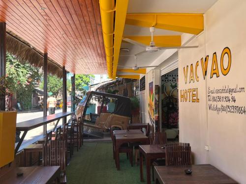 a restaurant with wooden tables and chairs on a street at VaoVao Hotel in Nosy Be