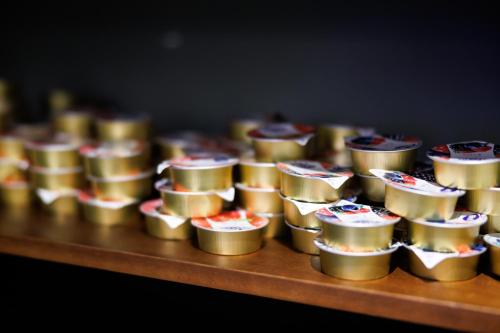 a row of gold cups on a wooden table at Casa San Giuseppe in Rome