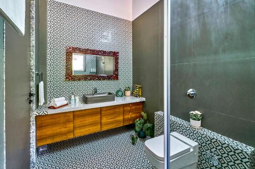 une salle de bain avec un lavabo et un miroir dans l'établissement SaffronStays Blissfort, à Malavli