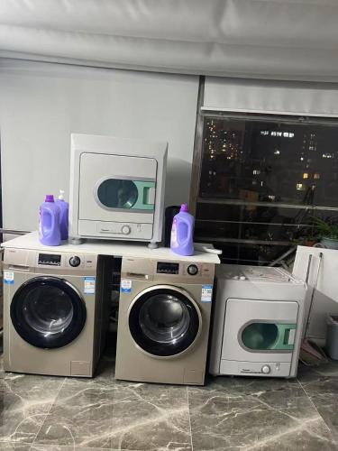 a room with two washing machines and a tv at Weiting Hotel Shanghai Jing'an Temple Nanjing West Road Subway Station Branch in Shanghai