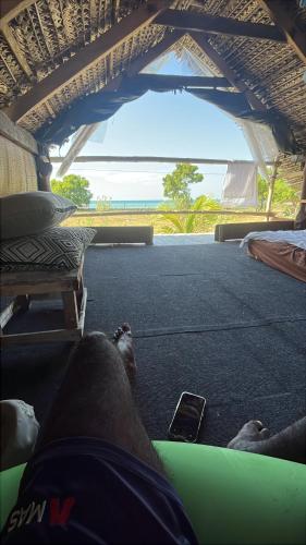 a person laying on the floor of a bus with a cell phone at Delft Jungle Beachfront Villa in Delft East
