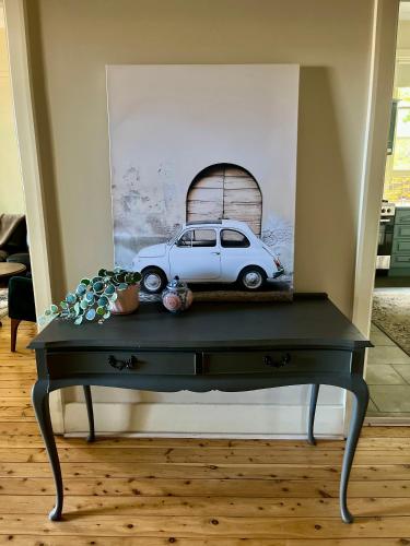 a black table with a picture of a car on it at Executive Cottage, Luxe 1930s Stay in the Heart in Albury