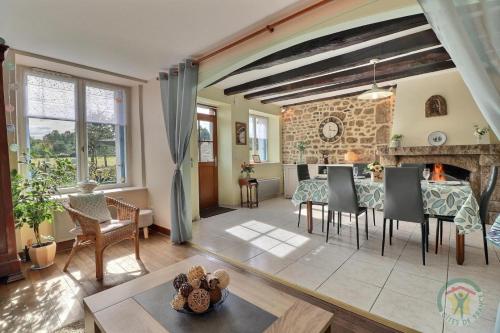 un salon avec une table et une cheminée dans l'établissement L'ascencerie, à Maen Roch