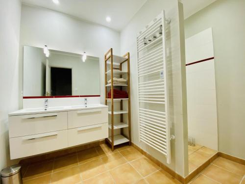 a bathroom with white cabinets and a mirror at Le cazal in Sainte-Eulalie