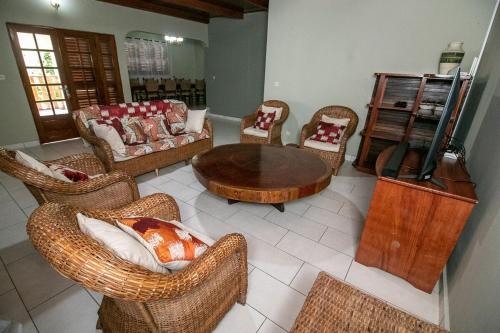 a living room with wicker chairs and a table at Villa NATH - Kribi centre-ville in Elabi