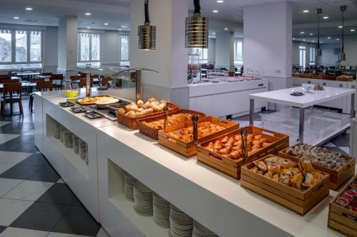 una línea de buffet con cestas de pan y otros alimentos en Balneario de Fitero - Hotel Bécquer, en Fitero