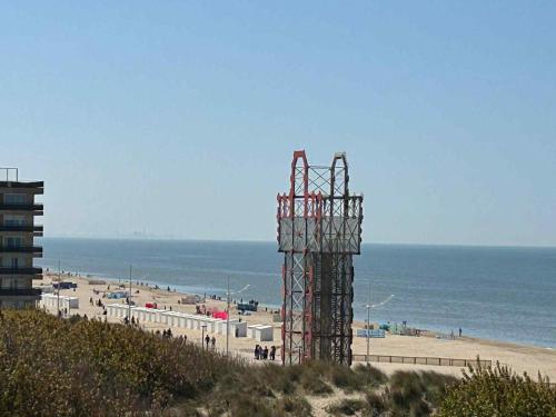 a view of a beach with a building and the ocean at Zeeparel XL in Koksijde