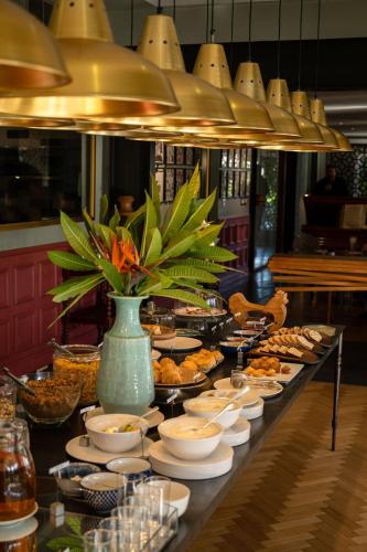 a buffet line with bowls and plates of food at Majeka House Boutique Hotel by The Living Journey Collection in Stellenbosch