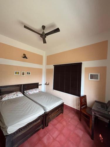 a bedroom with a bed and a ceiling fan at MANNINA MANE Vasa in Bengaluru