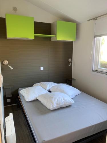 - un lit avec 4 oreillers dans l'établissement Mobil home Bahia DUO Prenium, à Genouillé