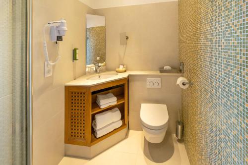 a bathroom with a sink and a toilet and a mirror at Best Western Premier Montfleuri in Sainte-Maxime