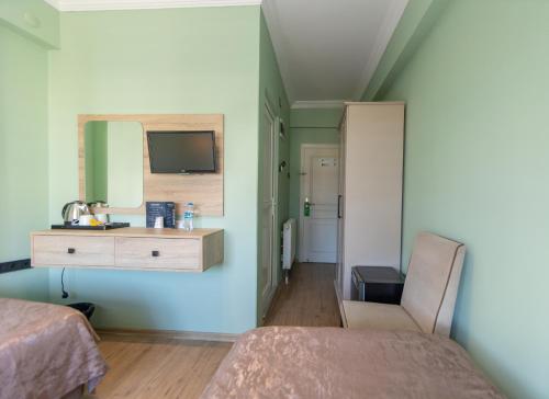 a bedroom with two beds and a sink and a mirror at Otel 57 in Sinop