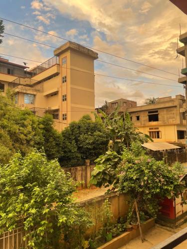 a view of a building with trees and plants at Pristine Stay in Guwahati