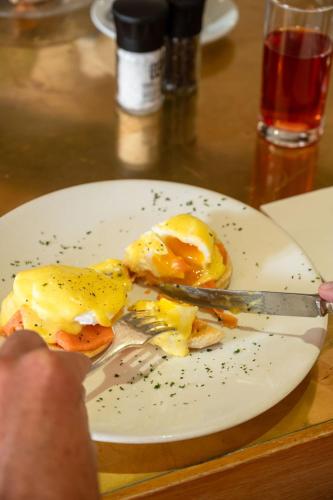 a plate with eggs on it with a knife and fork at Majeka House Boutique Hotel by The Living Journey Collection in Stellenbosch