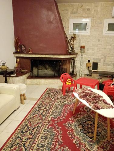 a living room with a fireplace and a red rug at Villa Kokalis Resort hotel in Gouves