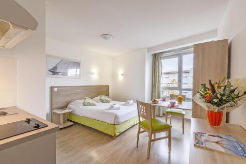 a hotel room with a bed and a table at Lagrange Apart'Hotel l’Escale Marine in La Rochelle