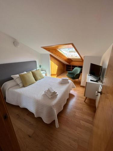 a bedroom with a large bed with a skylight at Ático en Cambados in Cambados