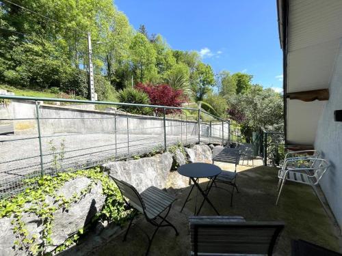 a patio with a table and chairs and a fence at Les Gîtes de La Maison Bleue d'Estialescq in Estialescq