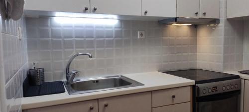 eine Küche mit Spüle und Herd in der Unterkunft Smart cozy apartment in Athens! in Athen