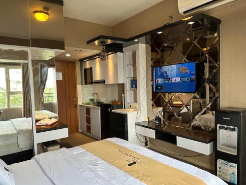 a bedroom with a bed and a tv on a wall at Apartment Thematic Lumens at Margonda Residence in Kemirimuka Dua
