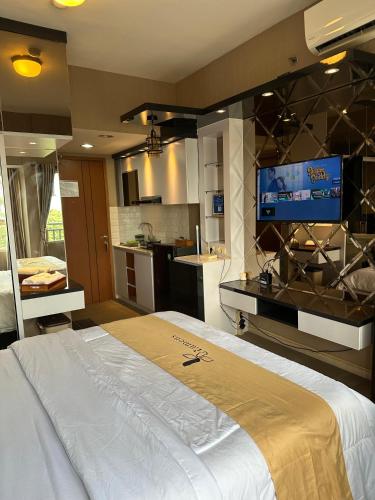 a bedroom with a large bed with a flat screen tv at Apartment Thematic Lumens at Margonda Residence in Kemirimuka Dua